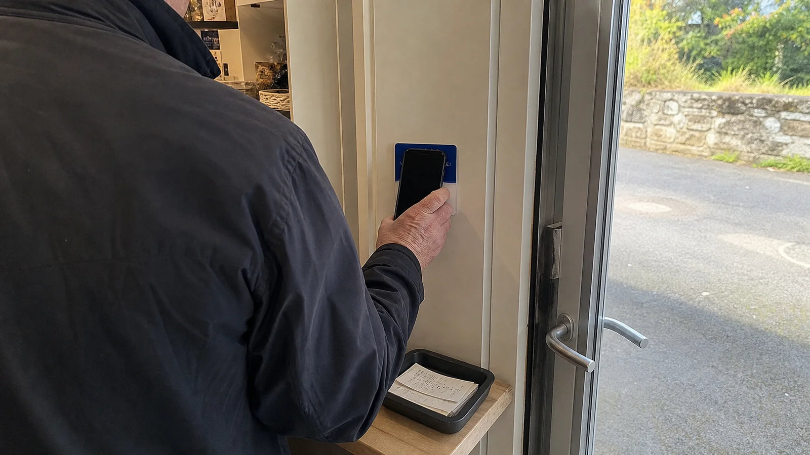 Make a landscape customer-phone photograph that exists because a departing customer is using the exa